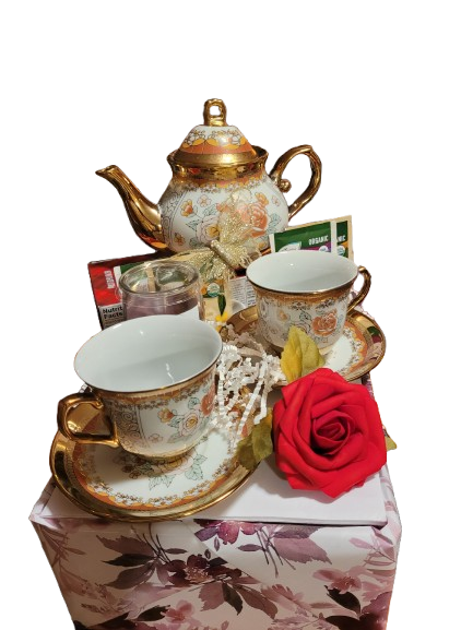 Floral gold-trimmed teapot and two teacups gift set with tea, a candle and a red rose